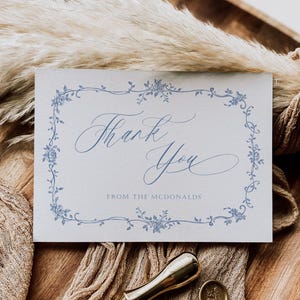 May include: A light blue thank you card with a floral border and the text "Thank You" in cursive script. The card also includes the text "From the McDonalds".