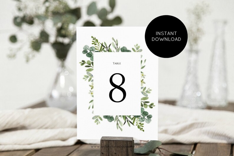 May include: A printable wedding table number card with a green watercolor floral border and the text "Table 8" in black.