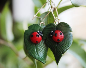 Ladybird on a leaf earrings handsculpted in polymer clay with nickel free sterling silver ear wires.