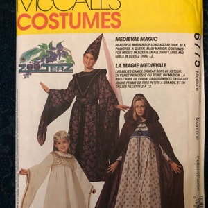 Puede incluir: Un patrón de costura para trajes medievales para niñas y mujeres. El patrón incluye tres trajes: un vestido de princesa morado y dorado, un vestido blanco con ribete dorado y una capa marrón con capucha con un vestido de estampado floral debajo. El patrón es para las tallas 2-12 para niñas y XS a L para mujeres. El patrón es de McCall's Costumes.