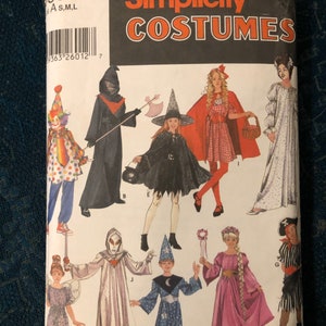 May include: Simplicity Costumes sewing pattern number 934 for children's Halloween costumes. The pattern includes a witch, a ghost, a fairy, a wizard, a princess, a pirate, a clown, a red riding hood, and a grim reaper. The pattern is for sizes small, medium, and large.