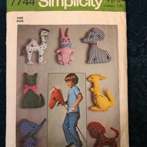 May include: A vintage Simplicity sewing pattern for making stuffed animals. The pattern includes instructions for making a camel, rabbit, dog, cat, horse, kangaroo, elephant, and lion. The pattern is for one size and is priced at $1.75. The pattern is from the 1970s.