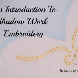 May include: White fabric with the text "An Introduction To Shadow Work Embroidery" in black script. A light blue patch is in the upper left corner. Yellow embroidery creates a floral design in the lower right corner. The text "by Kathy Dykstra" is in the lower right.