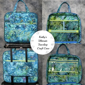 May include: A blue and green fabric travel craft case with multiple pockets and compartments. The case has a zipper closure and a handle. The case is labeled "Kathy's Ultimate Traveling Craft Case".