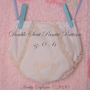 May include: White double seat panty pattern with lace trim and a heart design. The pattern is for sizes 0-6. The text "Double Seat Pantie Pattern sz. 0-6 Kathy Dijkstra ©2020" is printed on the fabric.