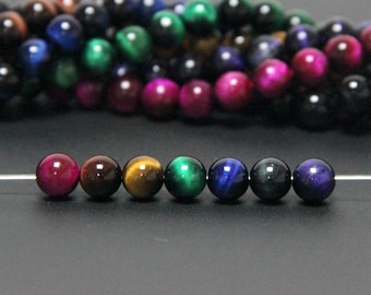May include: A strand of colorful tiger's eye beads in various shades of blue, green, brown, and red. The beads are round and smooth, and they have a shimmering, iridescent effect.
