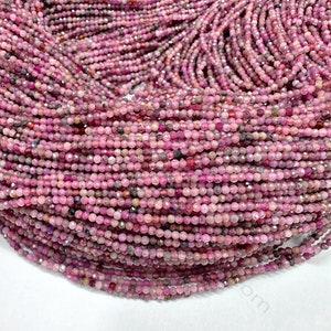 May include: A strand of pink ruby beads, approximately 2mm in size, with a faceted finish. The beads are strung on a clear thread and are ready for jewelry making.