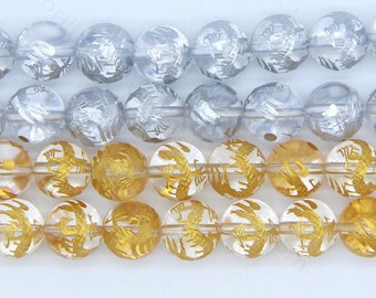 May include: Three strands of round, clear glass beads with gold and silver etched designs. The beads are arranged in rows, with the gold beads on the bottom, the silver beads in the middle, and the clear beads on top.