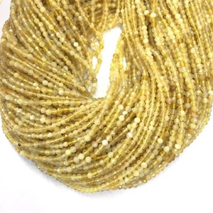 May include: A strand of yellow opal beads, approximately 2mm in size. The beads are faceted and have a translucent appearance.