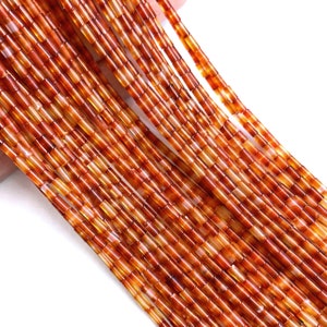 May include: A strand of orange carnelian beads, each bead is a small, rectangular tube.