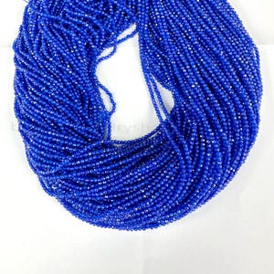 Puede incluir: Una hebra de cuentas de piedras preciosas facetadas azules. Las cuentas son pequeñas y redondas, y están enhebradas en un hilo transparente. Las cuentas están dispuestas en un patrón circular, y todas son del mismo tamaño y forma.