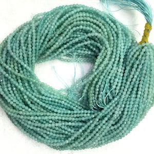 Può includere: Un filo di perle di acquamarina blu chiaro, di circa 2 mm di dimensione. Le perle sono sfaccettate e hanno una finitura liscia e lucida. Il filo è lungo circa 40 cm.