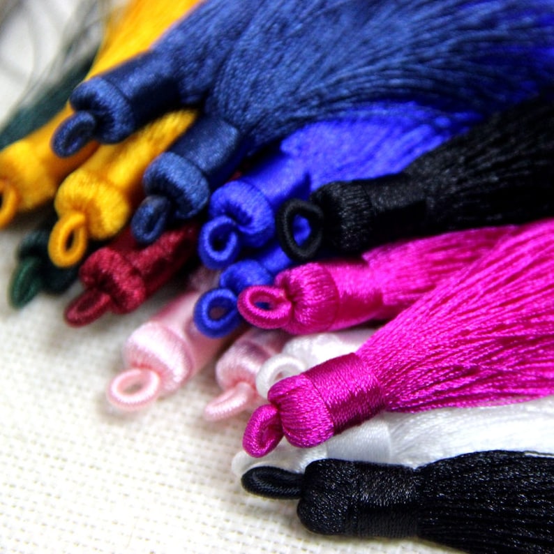 May include: Assortment of colorful tassel trims in various colors, including navy blue, royal blue, black, burgundy, pink, white, and yellow. The tassels are made of soft, silky fabric and are perfect for adding a touch of elegance to any project.