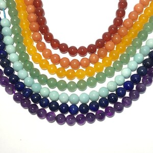 May include: A rainbow of gemstone beads, including amethyst, lapis lazuli, turquoise, green aventurine, citrine, carnelian, and red jasper.