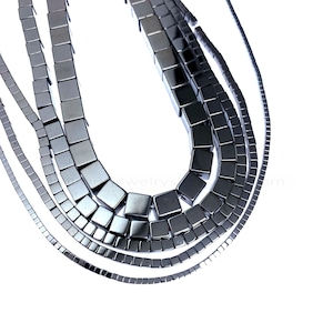 Può includere: Tre fili di perline quadrate nere, ogni filo con una dimensione di perlina diversa. Le perline sono in ematite.