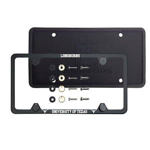 May include: Black metal license plate frame with the words "Longhorns" and "University of Texas" in white lettering. The frame includes a black rubber license plate cover with a honeycomb pattern.
