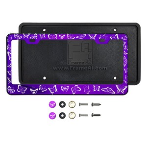 May include: Purple license plate frame with a white butterfly design. The frame is made of metal and has a black plastic backing. It comes with two screws and two caps.