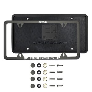 May include: A black license plate frame set with the text "ALUMNI" and "PURDUE UNIVERSITY" in white. The set includes a black license plate backing, a black frame, and mounting hardware. The FrameAi logo and website are visible.