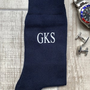 May include: Dark blue socks with white embroidered initials "GKS".