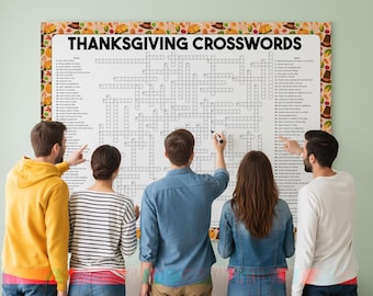 Op de afbeelding: Een grote Thanksgiving-kruiswoordpuzzel met de woorden "THANKSGIVING CROSSWORDS" bovenaan. De puzzel is omgeven door een decoratieve rand met herfstthema-illustraties. Verschillende mensen staan rond de puzzel, wijzen en schrijven.