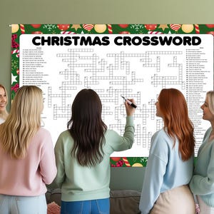 Op de afbeelding: Een groot kerstkruiswoordraadsel met een feestelijke rand wordt op een muur weergegeven. Verschillende mensen staan rond de puzzel, waarbij &eacute;&eacute;n persoon een stift vasthoudt. Het kruiswoordraadsel bevat de woorden "CHRISTMAS CROSSWORD" bovenaan.