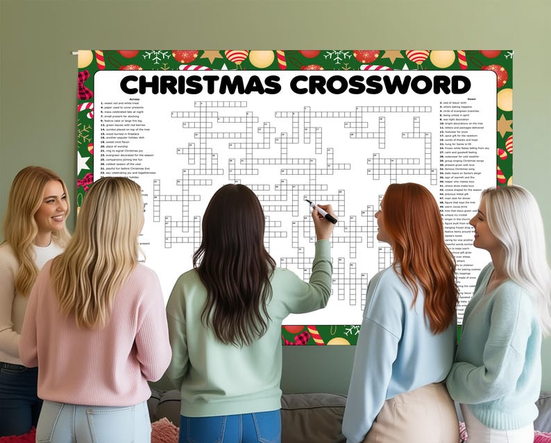 Op de afbeelding: Een groot kerstkruiswoordraadsel met een feestelijke rand wordt op een muur weergegeven. Verschillende mensen staan rond de puzzel, waarbij &eacute;&eacute;n persoon een stift vasthoudt. Het kruiswoordraadsel bevat de woorden "CHRISTMAS CROSSWORD" bovenaan.
