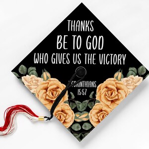 May include: Black graduation cap with a floral design and the text "Thanks be to God who gives us the victory 1 Corinthians 15:57".