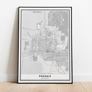 May include: A black and white map print of Phoenix, Arizona, in a black frame. The map shows the city's streets and landmarks.