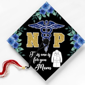 May include: Black graduation cap with a gold glitter "NP" and a blue and green floral design. The cap has a white medical coat icon and the text "This is one is for you Mom".