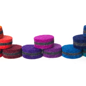 May include: A rainbow assortment of felt circles with black trim. The circles are stacked in a pyramid shape, with the largest circle at the bottom and the smallest circle at the top.
