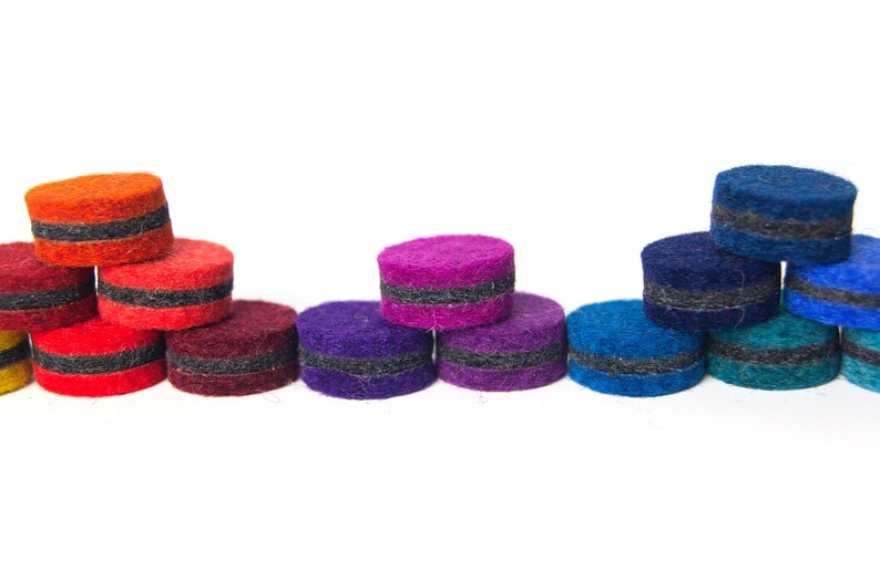 May include: A rainbow assortment of felt circles with black trim. The circles are stacked in a pyramid shape, with the largest circle at the bottom and the smallest circle at the top.