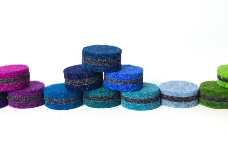 May include: A set of ten felt circles with a black stripe around the middle. The circles are arranged in a rainbow pattern, starting with purple and ending with green.