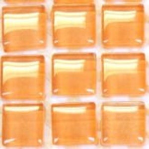 Puede incluir: Una hoja de pequeños azulejos de vidrio naranja translúcidos cuadrados.