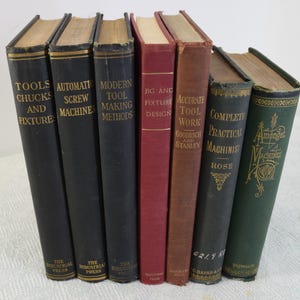 May include: A collection of eight vintage hardcover books about tools and machinery. The books have black, brown, red, and green covers with gold lettering. The titles include "Tools Chucks and Fixtures", "Automatic Screw Machines", "Modern Tool Making Methods", "Jig and Fixture Design", "Accurate Tool Work", "Complete Practical Machinist", and "Amongst Machines".