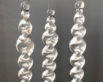 May include: Three clear glass icicle ornaments with a spiral design, hanging from thin strings.