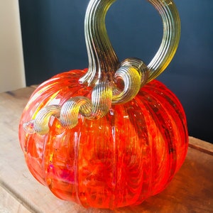 Orange jewel tone hand blown glass pumpkin with iridescent gold stem