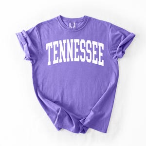 K&ouml;nnte beinhalten: Ein lila T-Shirt mit dem Wort "TENNESSEE" in wei&szlig; auf der Vorderseite.