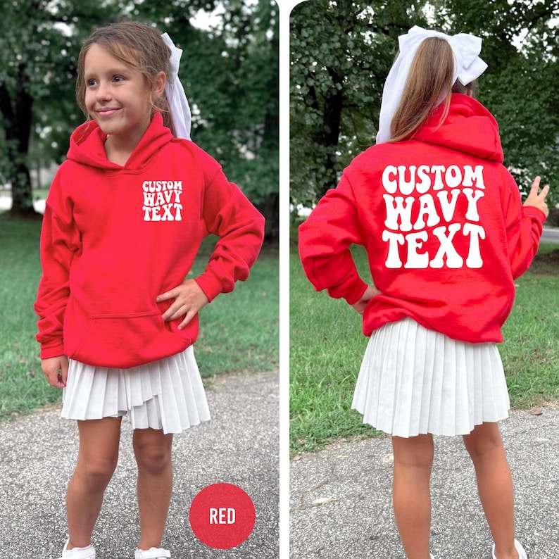 Puede incluir: Una sudadera roja con el texto "CUSTOM WAVY TEXT" en blanco en la parte delantera y trasera. Se combina con una falda plisada blanca. Un c&iacute;rculo rojo con la palabra "RED" est&aacute; en la parte inferior.