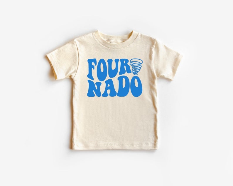 Pu&ograve; includere: Una maglietta color crema con una grafica blu che dice "FOURNADO" con una grafica di tornado blu sopra il testo.