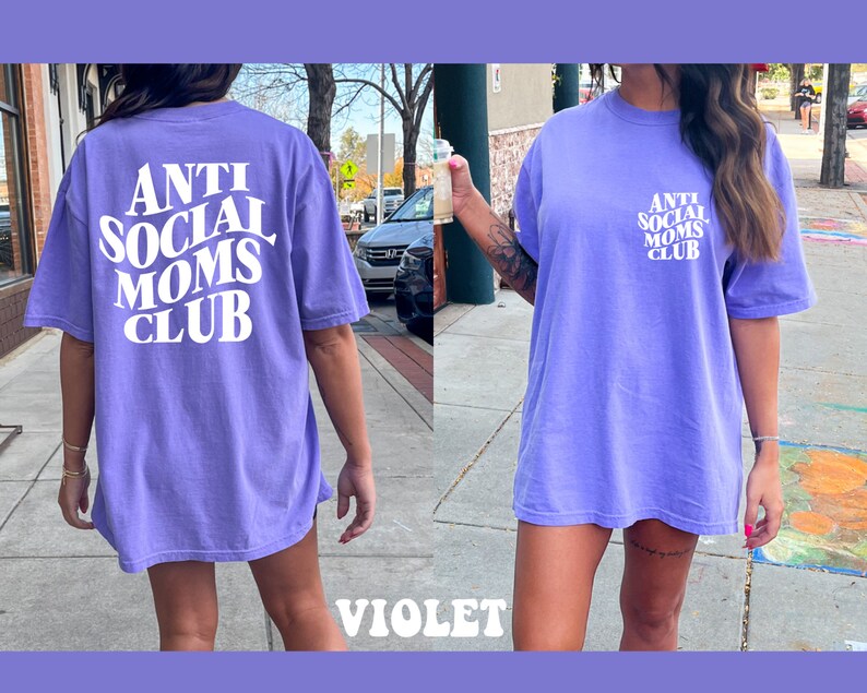 May include: A purple oversized t-shirt with the text "Anti Social Moms Club" in white. The shirt is made of a soft, comfortable material and has a relaxed fit.