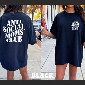 May include: Black oversized t-shirt with white text that reads "Anti Social Moms Club".