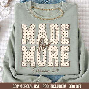 May include: A sage green crewneck sweatshirt featuring the text MADE FOR MORE in large, cream-colored block letters with brown polka dots. The word for is written in a brown script font between the lines, with Ephesians 2:10 below in brown.