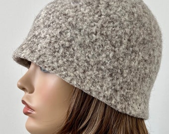 Pode incluir: Um chapéu cloche de lã marrom e branco com um ajuste folgado.