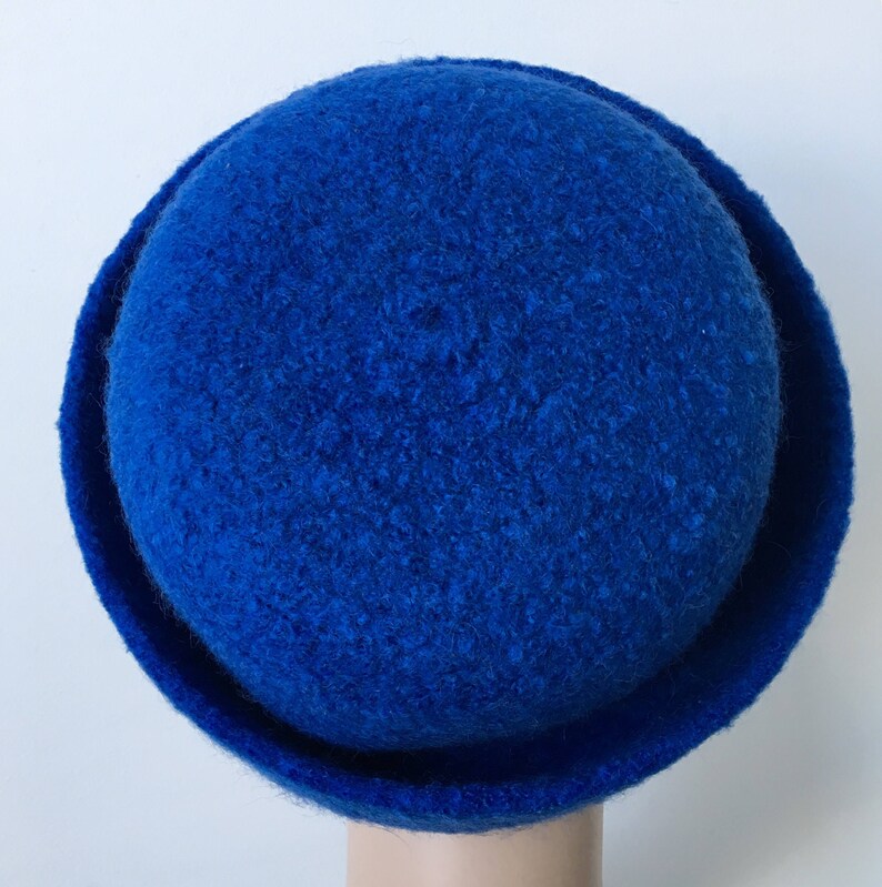 May include: A blue felt hat with a rounded crown and a wide brim.
