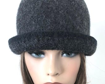 May include: A dark gray cloche hat with a rounded crown and a slightly upturned brim. The hat is made of a textured, felt-like material. The brim is a darker shade of gray than the crown. The hat is a stylish accessory.