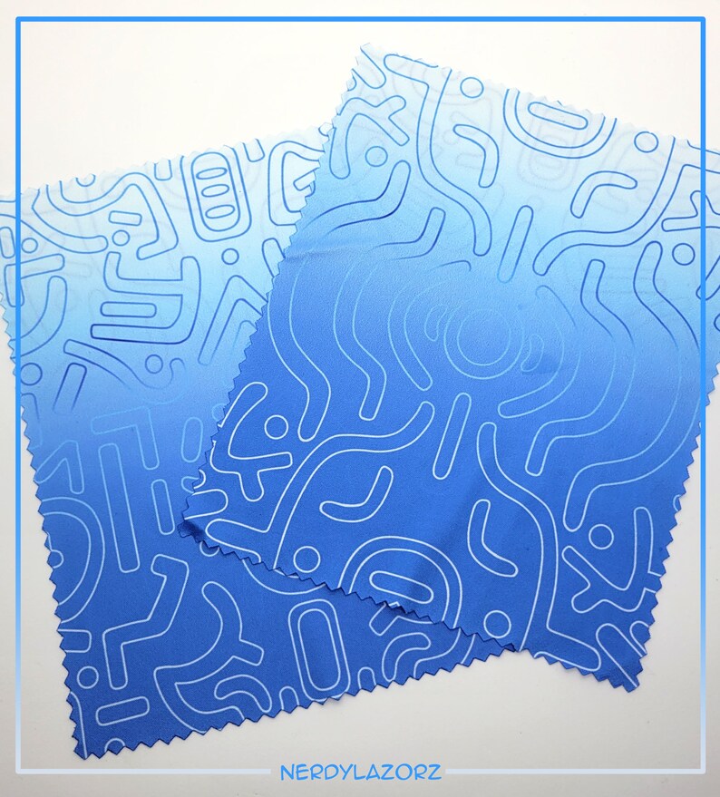Puede incluir: Dos pa&ntilde;os de limpieza de microfibra azules con un patr&oacute;n abstracto blanco. Los pa&ntilde;os est&aacute;n doblados uno encima del otro.