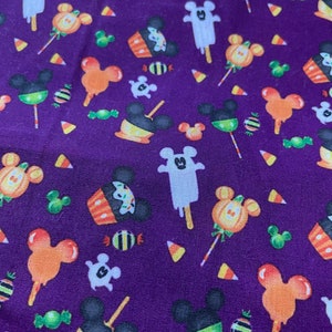 May include: Purple fabric with a repeating pattern of Halloween-themed Mickey Mouse characters. The characters are dressed as ghosts, pumpkins, and candy corn. There are also images of sweets and other Halloween treats.