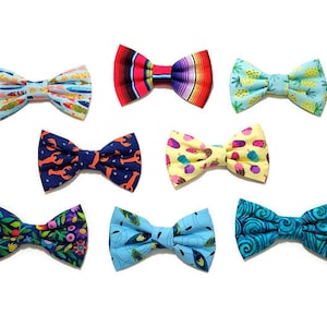 May include: Assortment of colorful bow ties with various patterns, including fish, pineapples, lobsters, ice cream cones, and swirls. The bow ties are made of fabric and are suitable for a variety of occasions.