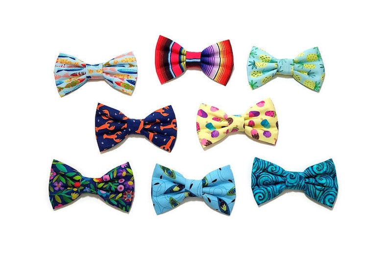 May include: Assortment of colorful bow ties with various patterns, including fish, pineapples, lobsters, ice cream cones, and swirls. The bow ties are made of fabric and are suitable for a variety of occasions.