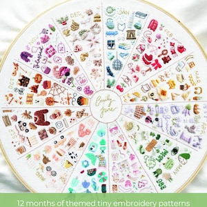 May include: A white embroidery hoop with a colorful embroidery design of 12 months of themed tiny embroidery patterns. The design is in a circle with each month represented by a different color and design. The months are labeled around the circle. The text "Emily June" is in the center of the circle.